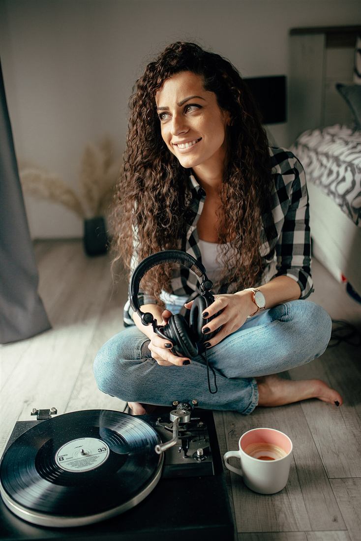 Mujer disfrutando su música junto a un tocadiscos